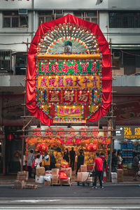 People in street market against buildings in city