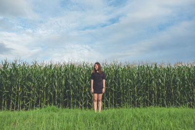 Woman standing on field against sky