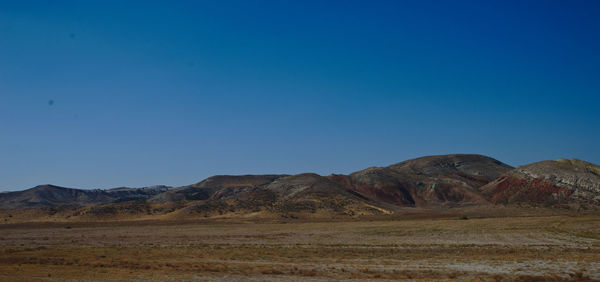 Scenic view of mountains against clear blue sky