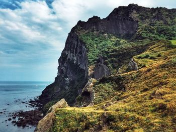 Rock formations by sea against sky