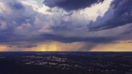 Aerial view of city against cloudy sky