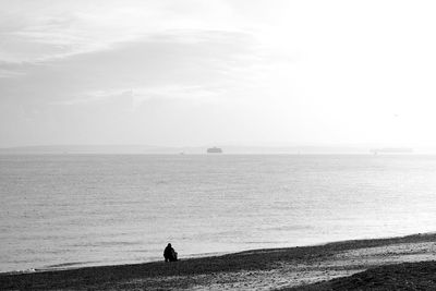 People looking at sea against sky