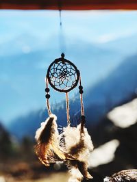 Close-up of feather hanging against sky