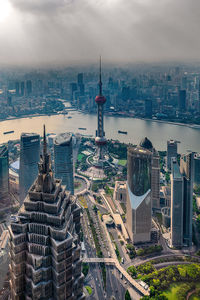 High angle view of modern buildings against cloudy sky