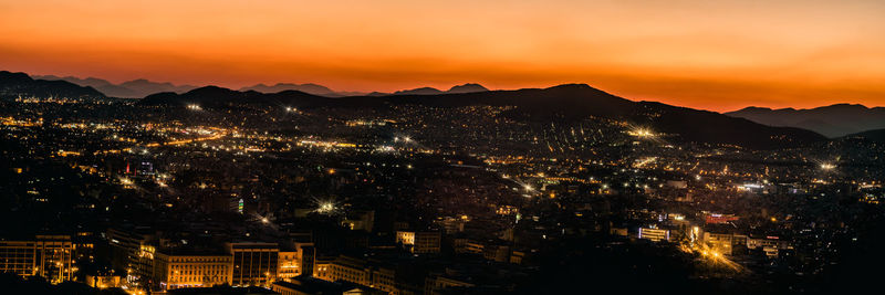 Illuminated cityscape against sky at night