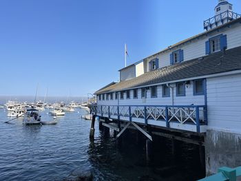 Sailboats moored on sea against buildings