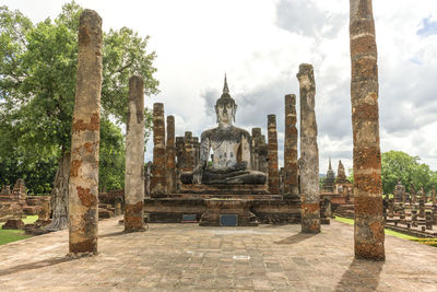 Statue amidst trees and buildings in temple