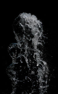 Close-up of water drops on glass over black background