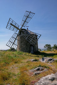 Traditional windmill on field against sky