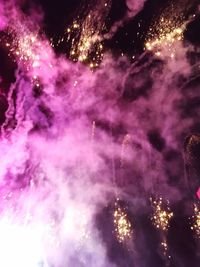 Low angle view of fireworks against sky at night