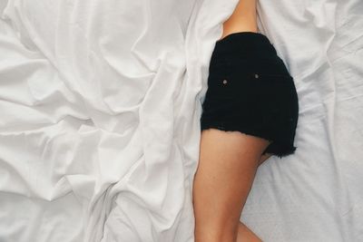 Midsection of woman lying on bed