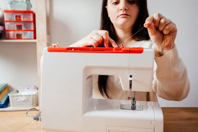 Young woman sewing at home