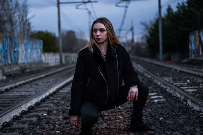 Woman standing on railroad track