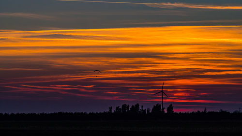 Scenic view of silhouette landscape against orange sky