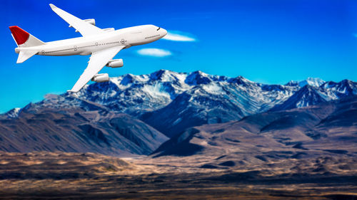 Scenic view of snowcapped mountains against blue sky