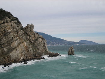 Scenic view of rocks in sea against sky