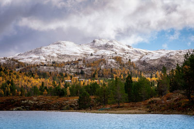 Scenic view of mountains and lake against cloudy sky