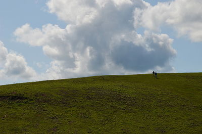 Friends walking on landscape against sky