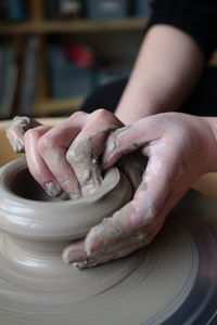 Cropped hands of woman making pottery