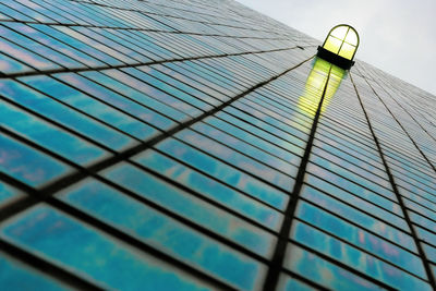 Low angle view of glass building against sky