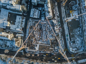 High angle view of cranes and buildings in city