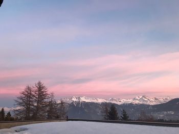 Scenic view of snowcapped mountains against sky at sunset