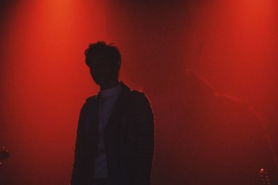 Silhouette man standing against red wall