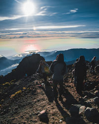 Rear view of people on rock against sky