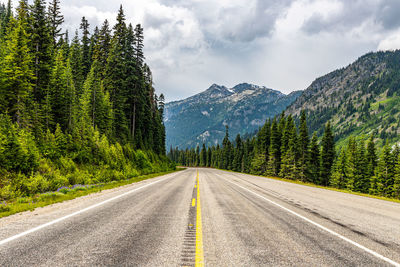 Road by trees against sky