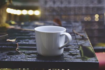 Close-up of coffee cup on wet table