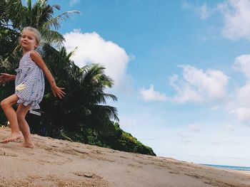 Portrait of girl running on beach against sky