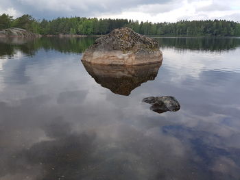 Reflection of rocks in lake against sky