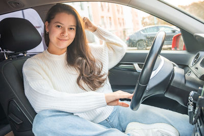 Young woman sitting in car