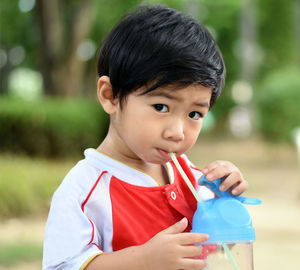 Portrait of cute boy drinking water from straw