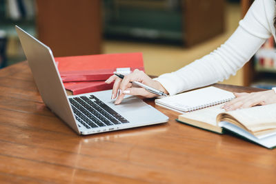 Midsection of man using laptop on table