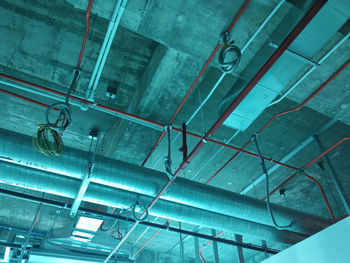 Low angle view of electric lamp hanging on ceiling in building