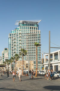 People on street against buildings in city