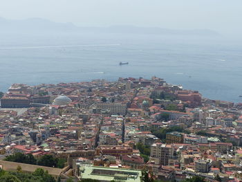 High angle view of buildings by sea against sky