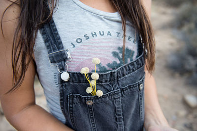 A woman collects flowers by the side of the road in joshua tree.