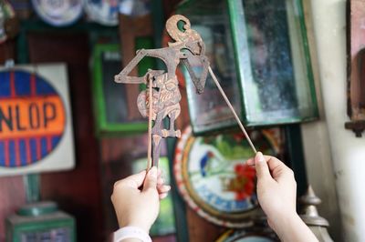 Cropped hands of woman holding puppet in store