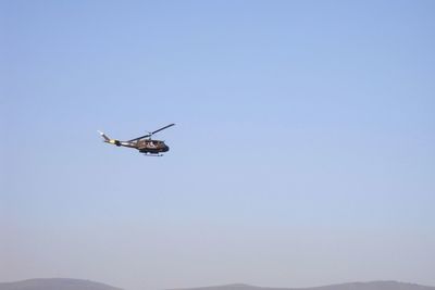 Low angle view of helicopter flying against clear sky