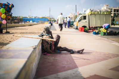 Beggar sitting on footpath