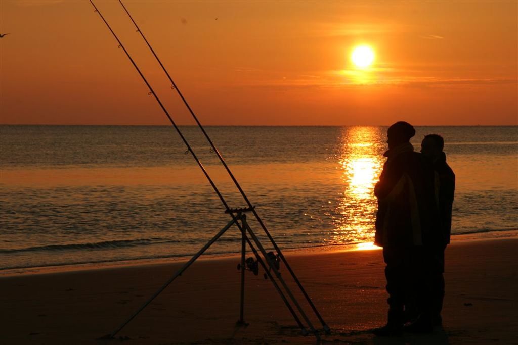 SILHOUETTE PERSON STANDING BY SEA AGAINST SUNSET SKY