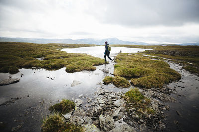 View of hiker crossing river