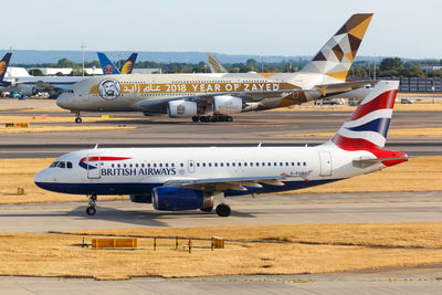 Airplane on airport runway against sky