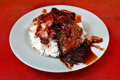 Close-up of char siu served with rice on table at restaurant