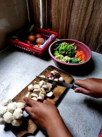 High angle view of hand holding bowl of table