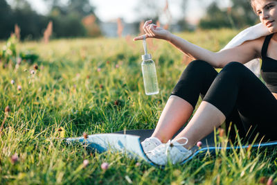 Midsection of woman with arms raised on field