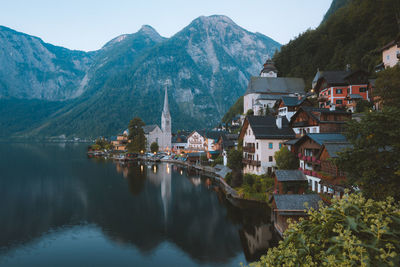 View of buildings by lake against mountain