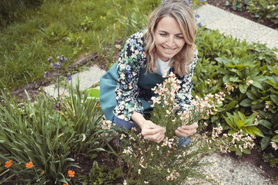 Portrait of young woman standing amidst plants